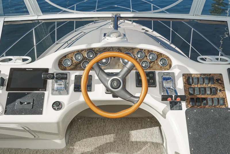 Slide: The Image of 1997 Sea Ray 420 Aft Cabin helm with wooden steering wheel and modern controls. - 28