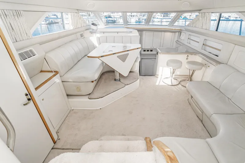 Slide: The Image of 1997 Sea Ray 420 Aft Cabin interior with white leather seating and panoramic windows. - 3