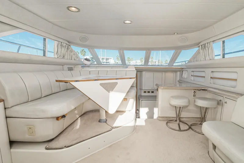 Slide: The Image of Interior of 1997 Sea Ray 420 Aft Cabin yacht with white seating and dining area. - 32