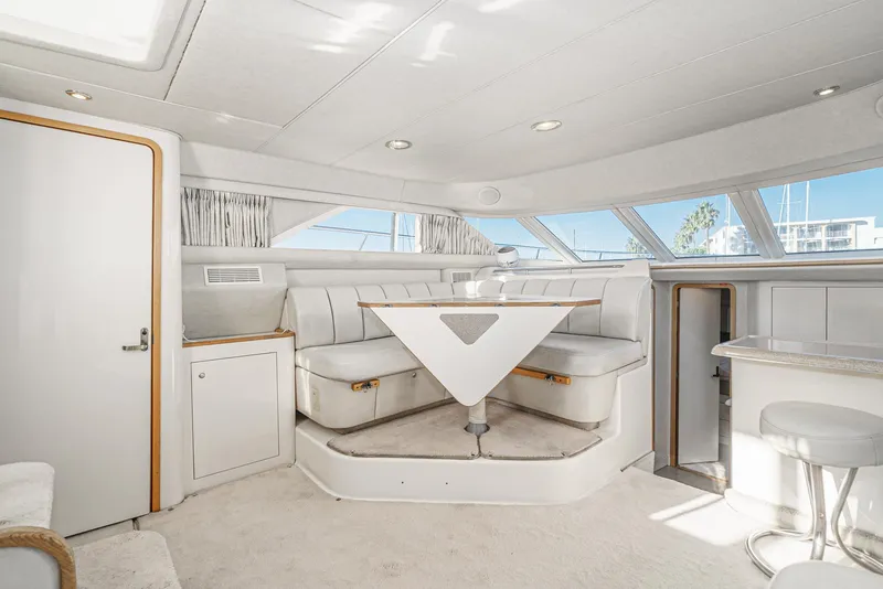 Slide: The Image of Interior of 1997 Sea Ray 420 Aft Cabin yacht with white seating and triangular table. - 33