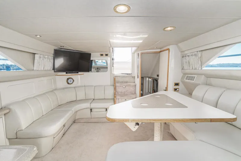 Slide: The Image of Interior of 1997 Sea Ray 420 Aft Cabin yacht with white leather seating and TV. - 35