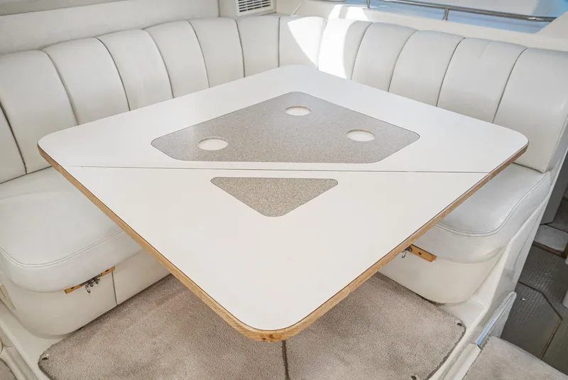 Slide: The Image of 1997 Sea Ray 420 Aft Cabin interior dining area with white cushioned seating. - 37