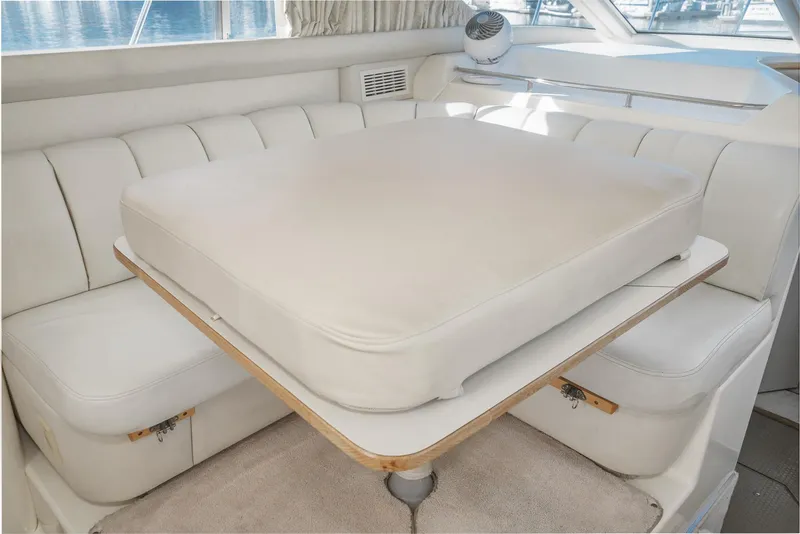 Slide: The Image of 1997 Sea Ray 420 Aft Cabin interior seating area with cushioned table. - 38