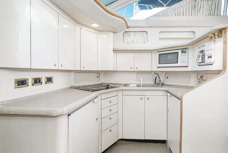 Slide: The Image of Modern kitchen in 1997 Sea Ray 420 Aft Cabin yacht with white cabinetry and appliances. - 41