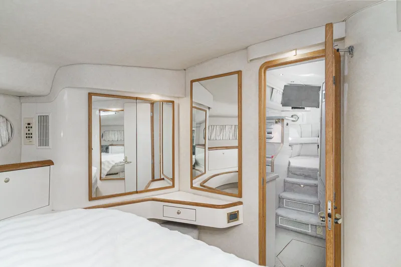 Slide: The Image of 1997 Sea Ray 420 Aft Cabin interior bedroom with mirrors and wooden accents. - 49