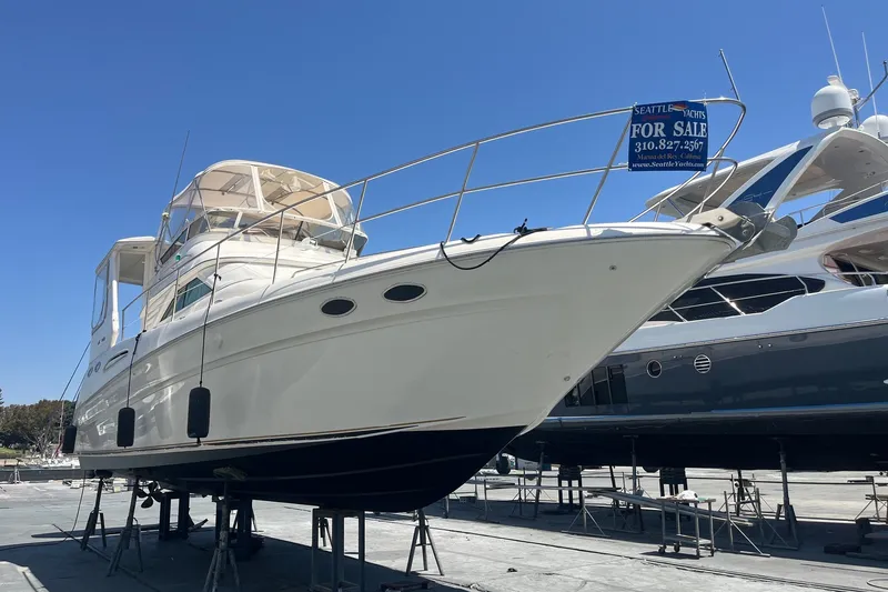 Slide: The Image of 1997 Sea Ray 420 Aft Cabin yacht for sale, displayed on stands under clear blue sky. - 77