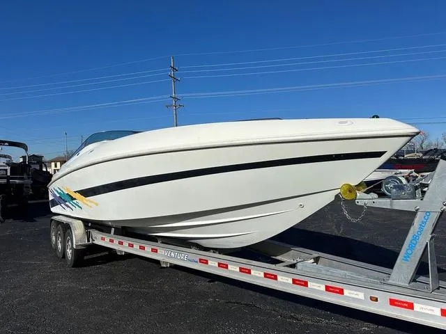 Slide: The Image of 1997 Baja Boss 302 speedboat on a trailer under clear blue sky. - 2