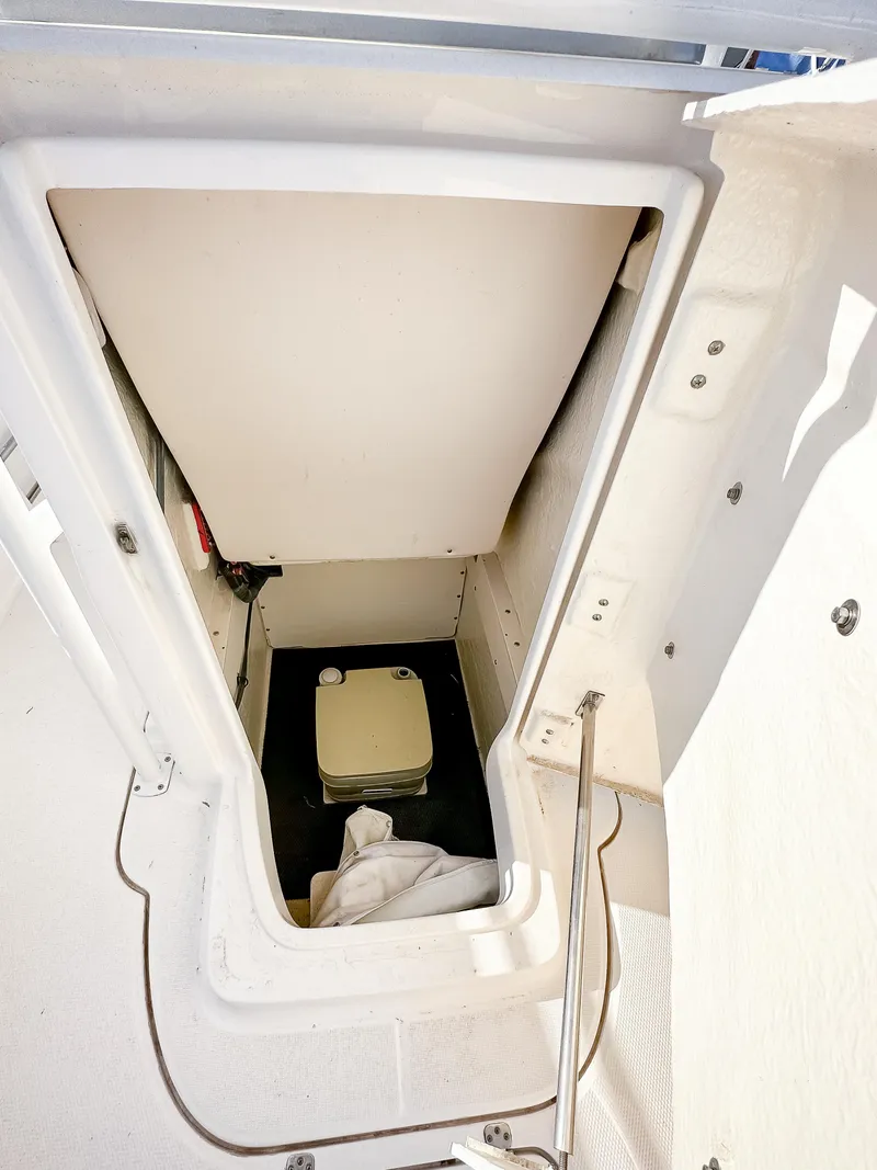 Slide: The Image of 2017 Robalo R222 boat interior storage compartment with portable toilet. - 10