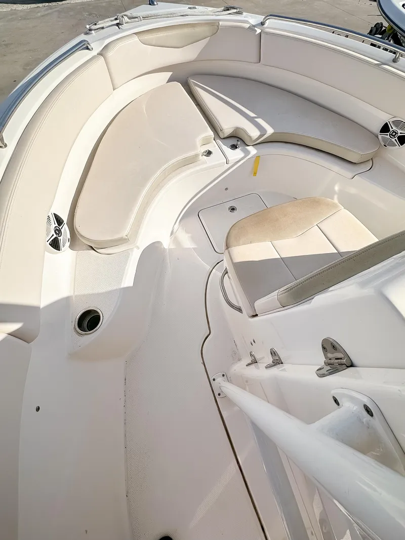 Slide: The Image of 2017 Robalo R222 boat interior with white seating and storage compartments. - 7