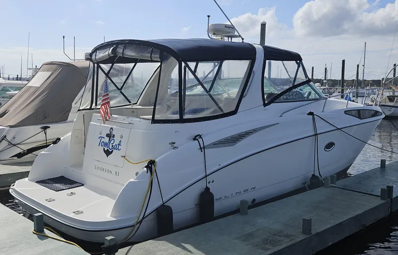 Slide: The Image of 2006 Bayliner 325 boat docked at a marina with a black canopy. - 1