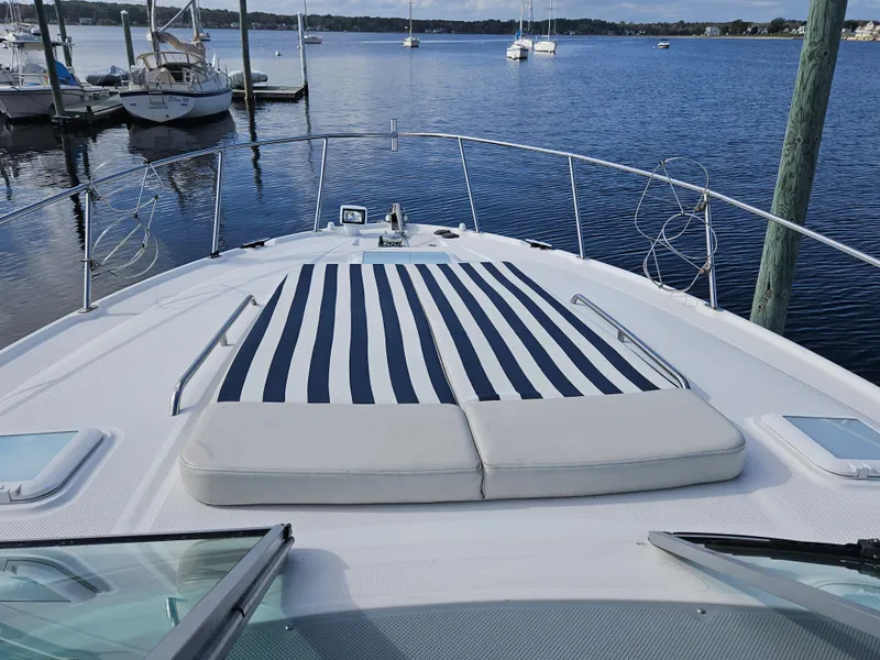 Slide: The Image of 2006 Bayliner 325 boat with striped sun pad on deck, docked at marina. - 6