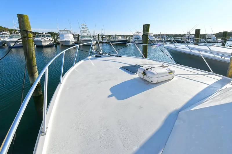 Slide: The Image of Torres 48 Enclosed Bridge 2000 yacht docked at marina, showcasing spacious deck and railing. - 16