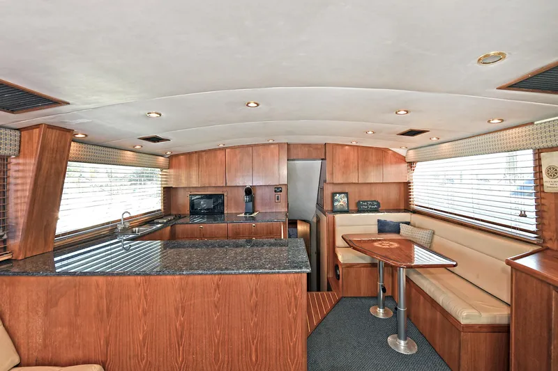 Slide: The Image of Luxurious interior of 2000 Torres 48 Enclosed Bridge yacht with modern kitchen and seating area. - 19