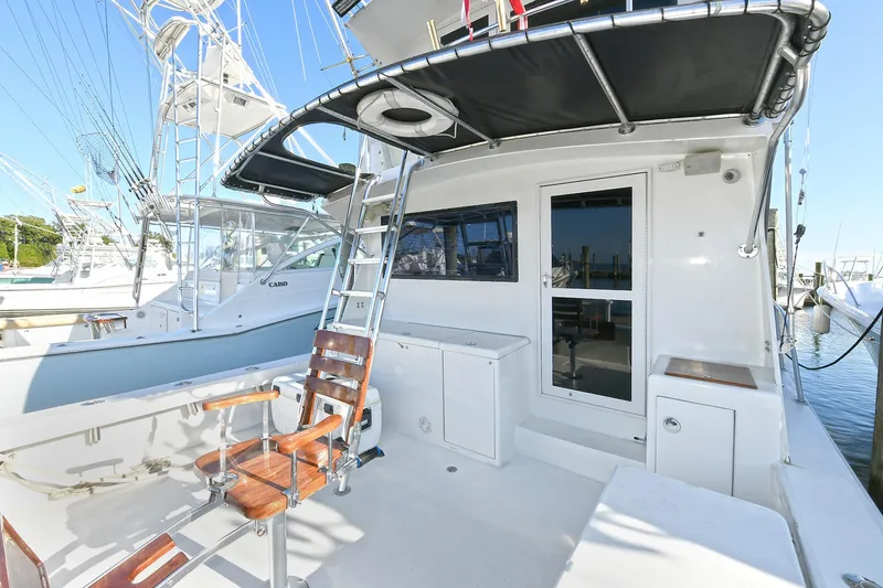 Slide: The Image of 2000 Torres 48 Enclosed Bridge yacht with fishing chair and ladder on deck. - 2