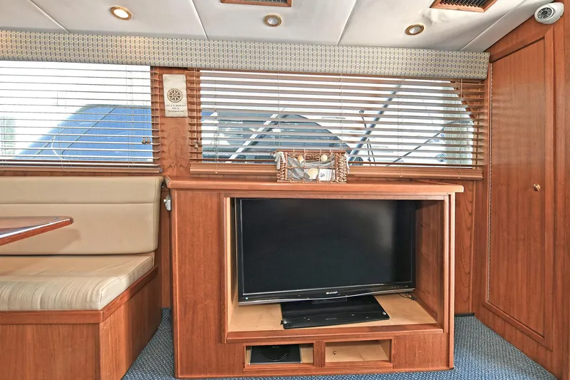 Slide: The Image of Interior of 2000 Torres 48 Enclosed Bridge yacht with TV and wooden cabinetry. - 21