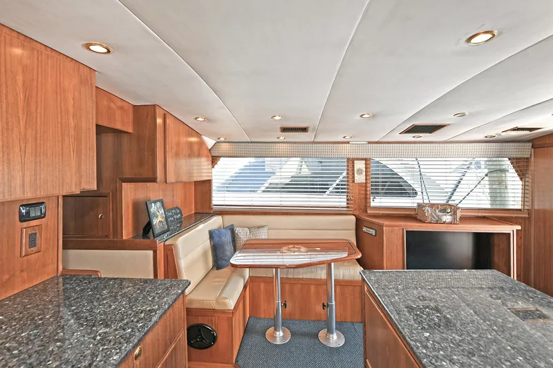 Slide: The Image of Interior of 2000 Torres 48 Enclosed Bridge yacht with wood finish and seating area. - 24
