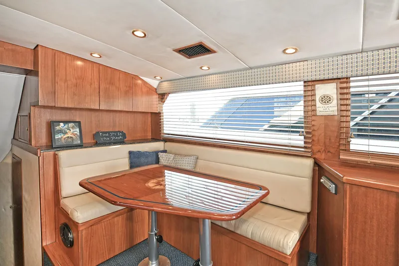 Slide: The Image of Interior of 2000 Torres 48 Enclosed Bridge yacht with wooden dining area and seating. - 25