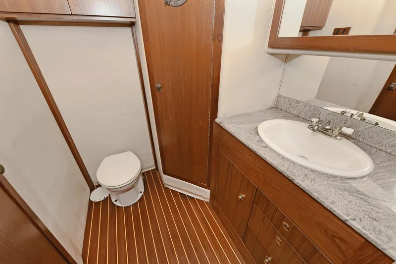 Slide: The Image of Bathroom interior of 2000 Torres 48 Enclosed Bridge yacht with wood accents and sink. - 30