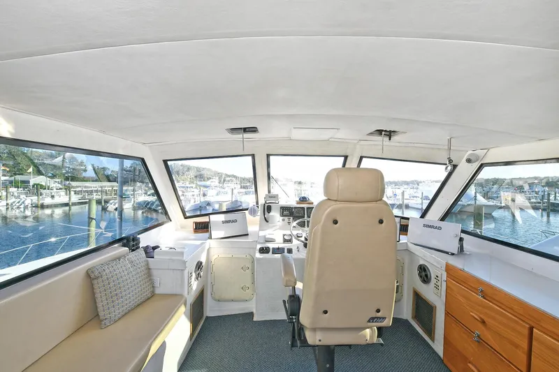 Slide: The Image of Interior of 2000 Torres 48 Enclosed Bridge yacht, featuring helm and seating area. - 7