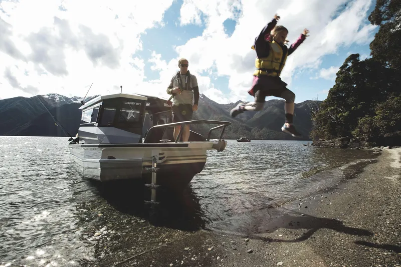 Slide: The Image of 2023 Stabicraft 2250 UltraCab WT on a scenic lake with people enjoying water activities. - 10