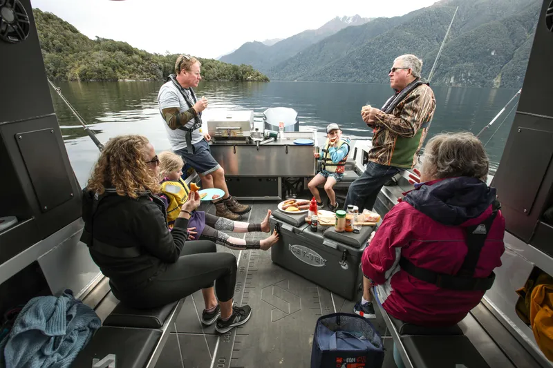 Slide: The Image of Family enjoying a meal on a 2023 Stabicraft 2250 UltraCab WT boat. - 9
