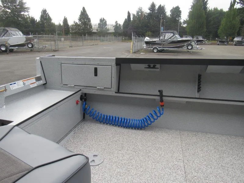 Slide: The Image of 2024 Alumaweld 20 Adventurer boat interior with storage compartments and coiled blue hose. - 10