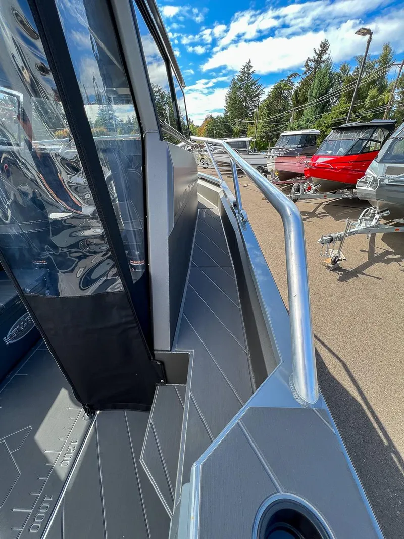 Slide: The Image of 2023 Stabicraft 2250 Ultra Centercab boat deck with railing and clear sky background. - 23