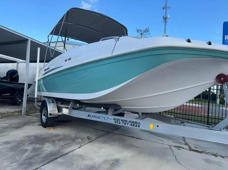 Slide: The Image of 2024 Hurricane SunDeck Sport 188 OB boat on a trailer with a canopy. - 1