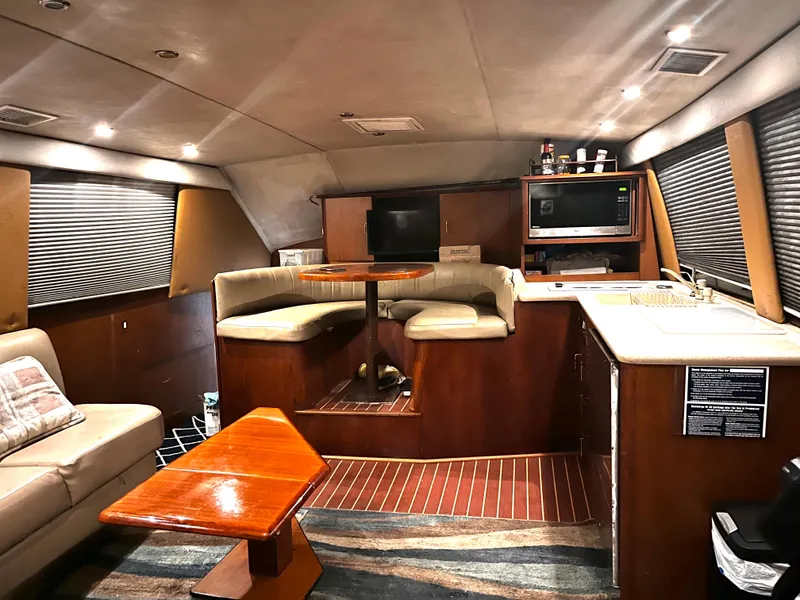 Slide: The Image of Interior of 1998 Ocean Yachts 40 Super Sport with seating, table, and kitchenette. - 8