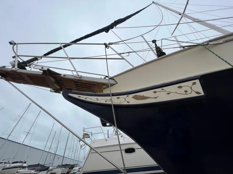 Slide: The Image of Krogen 38 sailboat from 1986 docked in a marina, close-up of the bow. - 10