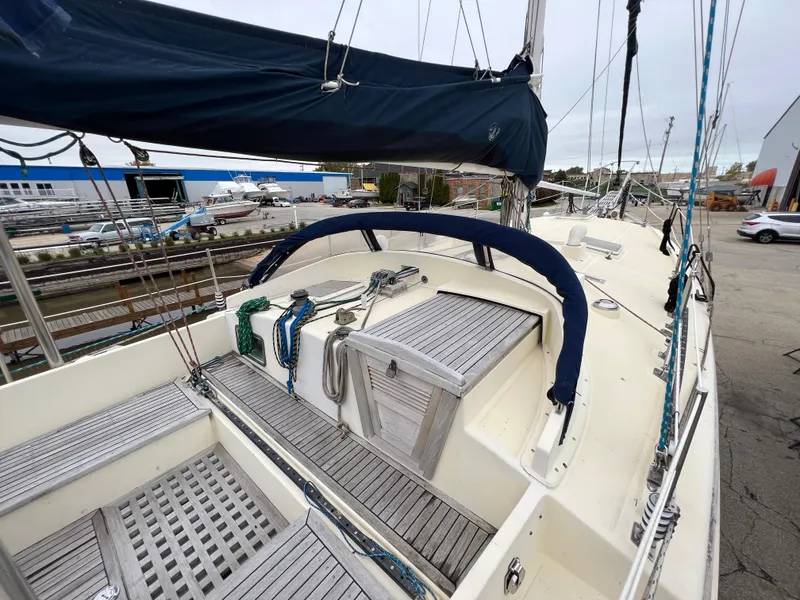 Slide: The Image of 1986 Krogen 38 sailboat with blue canvas cover docked at a marina. - 11