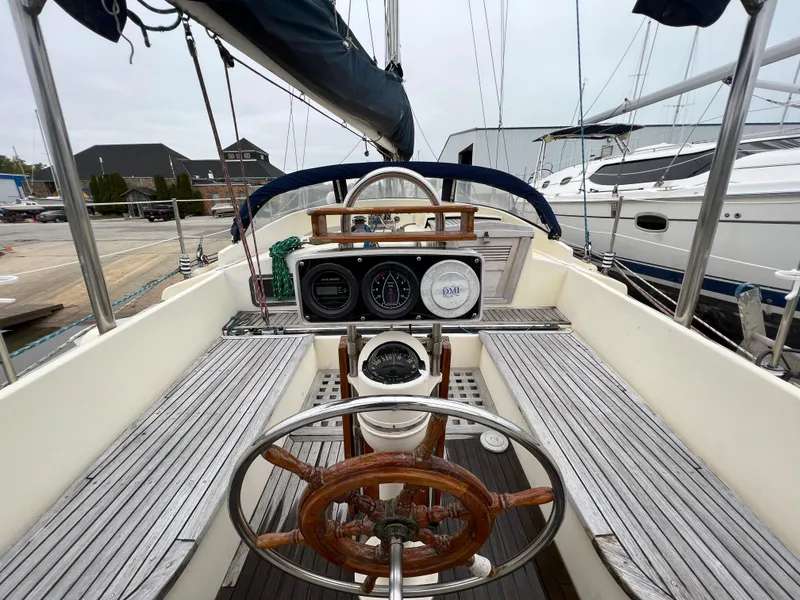 Slide: The Image of 1986 Krogen 38 sailboat cockpit with wooden steering wheel and navigation instruments. - 13