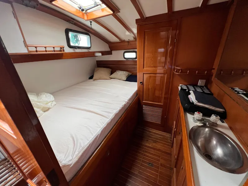 Slide: The Image of 1986 Krogen 38 boat cabin with bed, sink, and wooden interior. - 24