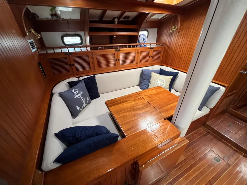 Slide: The Image of 1986 Krogen 38 yacht interior with cozy dining area and nautical-themed cushions. - 27