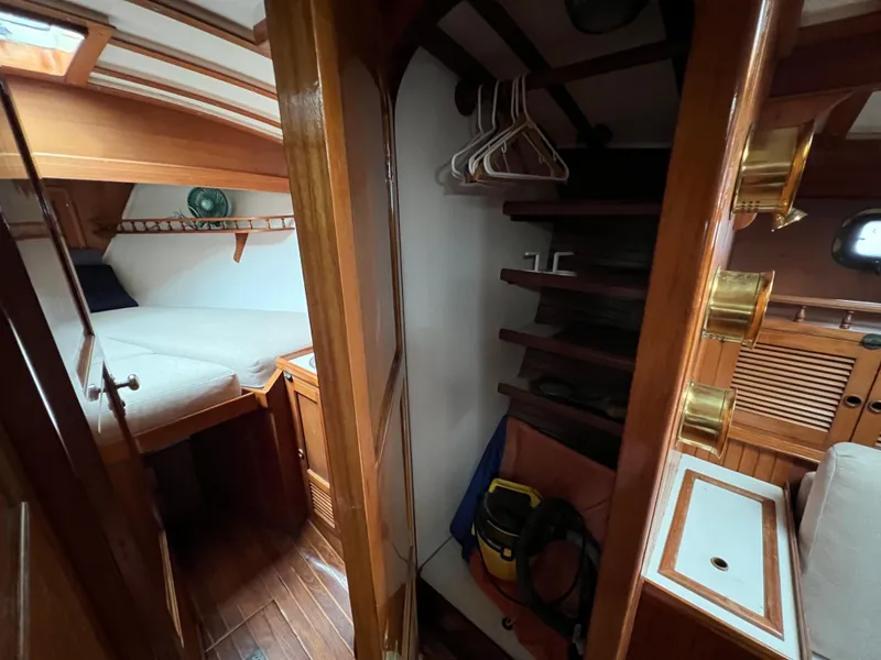 Slide: The Image of 1986 Krogen 38 interior cabin with bed, wooden shelves, and storage space. - 33