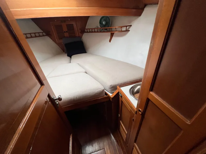 Slide: The Image of 1986 Krogen 38 cabin interior with V-berth and wooden cabinetry. - 34