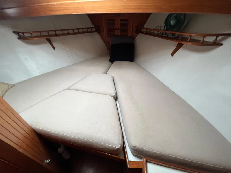 Slide: The Image of 1986 Krogen 38 boat interior cabin with cushioned V-berth and wooden shelves. - 35