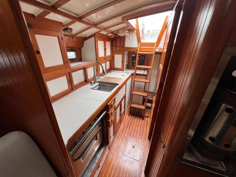 Slide: The Image of 1986 Krogen 38 yacht interior with wooden cabinetry and galley kitchen. - 42