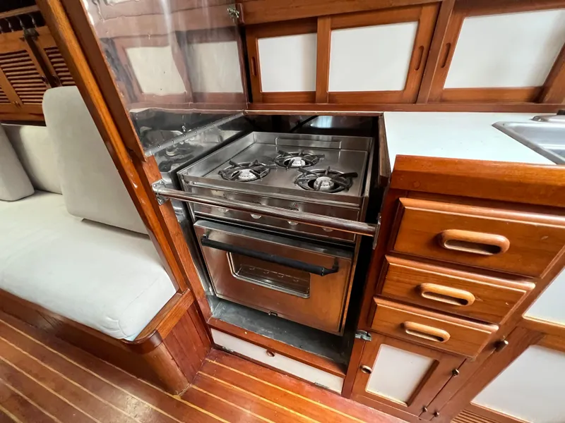Slide: The Image of 1986 Krogen 38 yacht kitchen with stove, oven, and wooden cabinetry. - 43