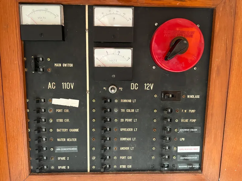 Slide: The Image of 1986 Krogen 38 electrical control panel with AC 110V and DC 12V switches and gauges. - 47