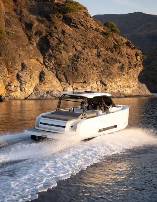 Slide: The Image of 2024 De Antonio Yachts D36 OPEN cruising near rocky coastline. - 2