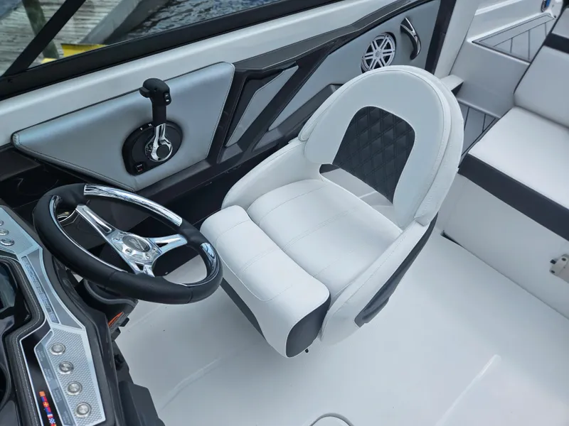 Slide: The Image of 2024 Monterey 215SS boat interior with white captain's chair and steering wheel. - 18