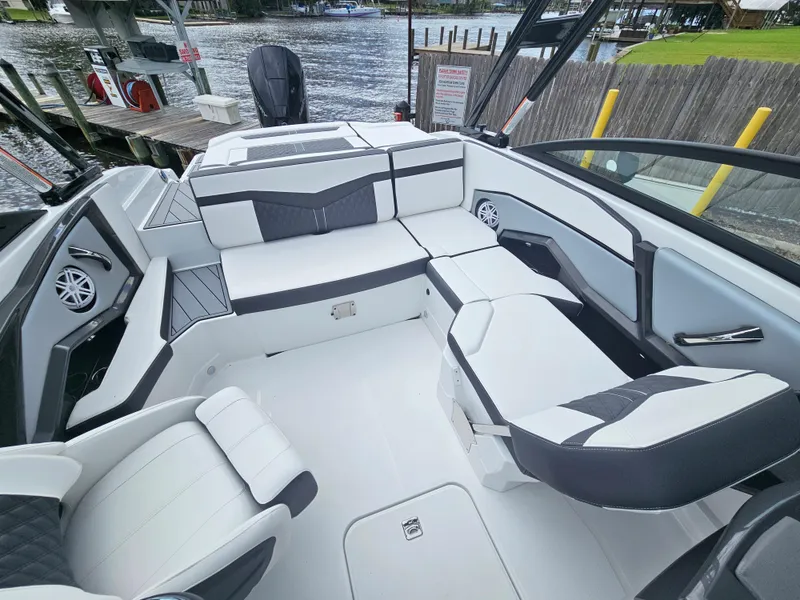 Slide: The Image of 2024 Monterey 215SS boat interior with white and black seating, docked by the water. - 26