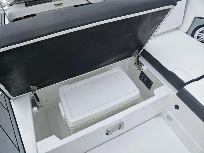 Slide: The Image of 2024 Monterey 215SS boat with open storage compartment and cooler. - 27