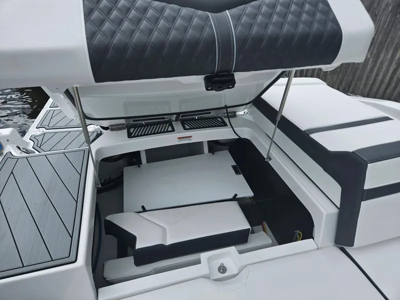 Slide: The Image of 2024 Monterey 215SS boat with open engine compartment and cushioned seating. - 31