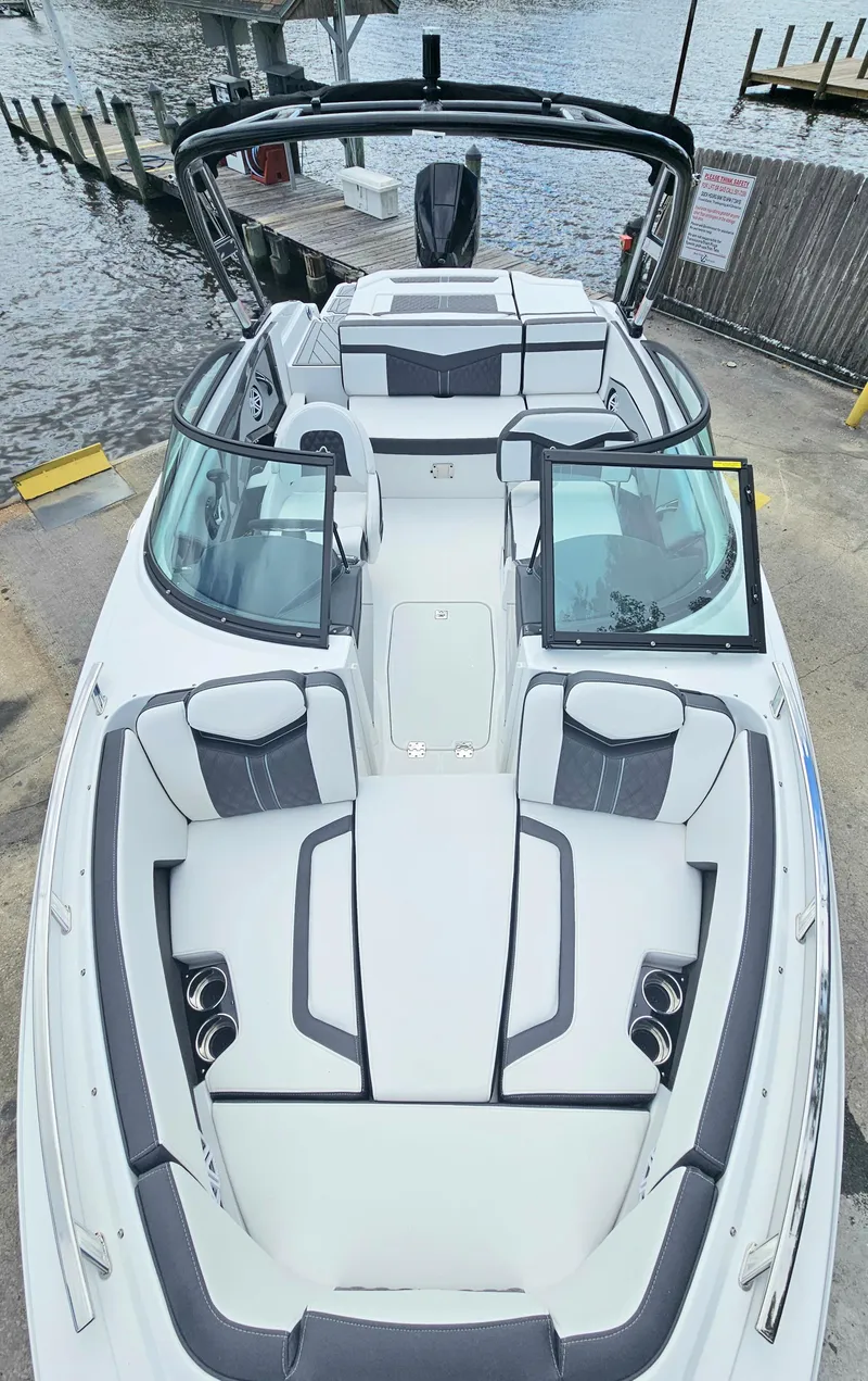 Slide: The Image of 2024 Monterey 215SS boat docked, featuring spacious seating and sleek design. - 6