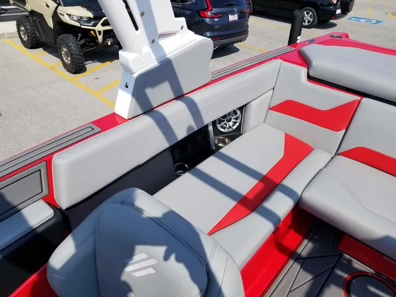 Slide: The Image of 2024 ATX Surf Boats 22 Type-S interior with red and gray seating, parked outdoors. - 18