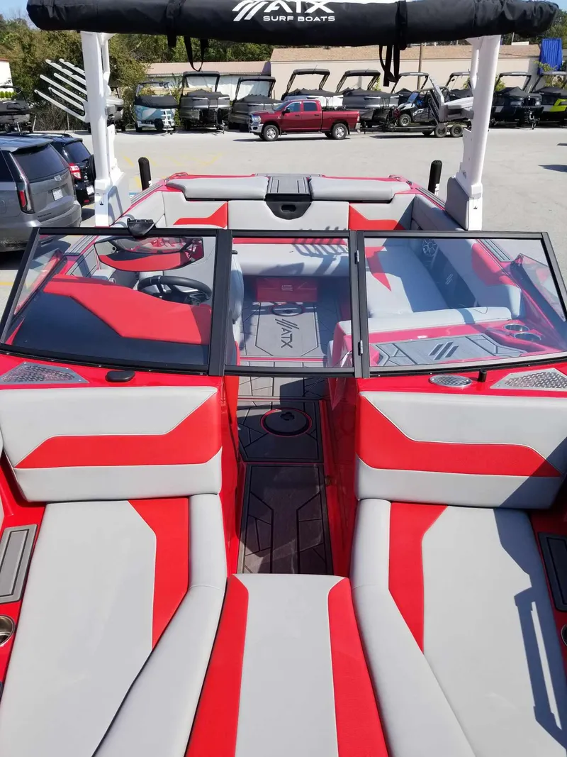 Slide: The Image of 2024 ATX Surf Boats 22 Type-S with red and gray interior, docked outdoors. - 8