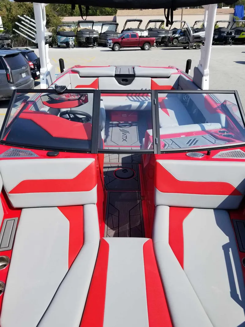 Slide: The Image of 2024 ATX Surf Boats 22 Type-S with red and gray interior, docked outdoors. - 9