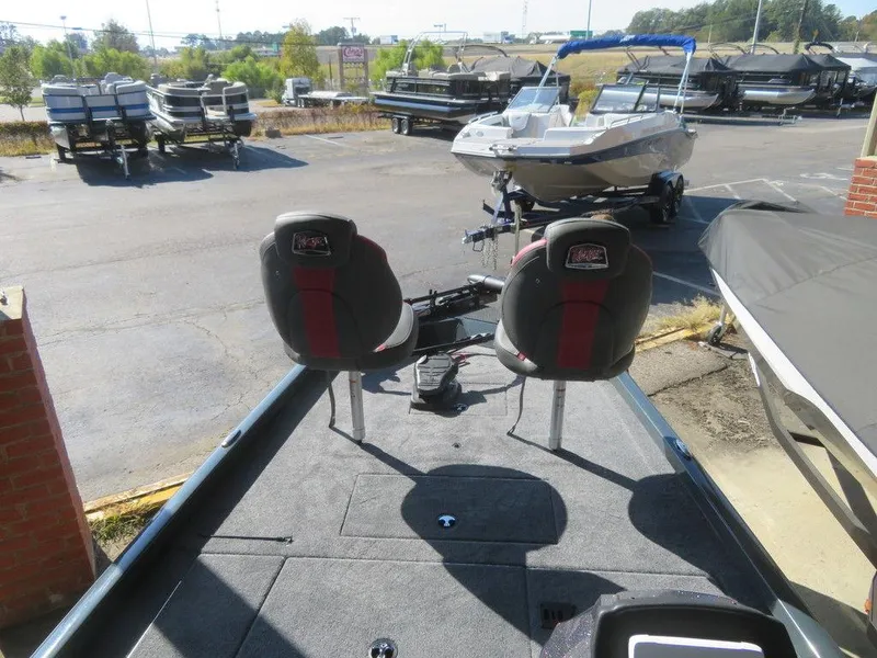 Slide: The Image of 2023 Ranger RT178C fishing boat with dual seats and trolling motor in a dealership lot. - 12